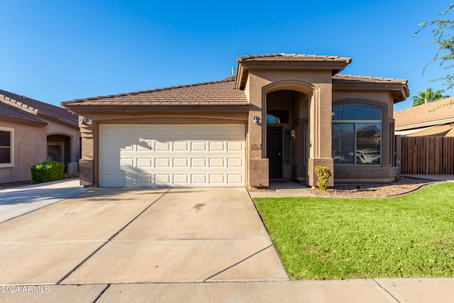 view of front of house featuring a garage and a front lawn