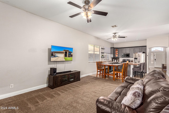 living room featuring dark colored carpet and ceiling fan