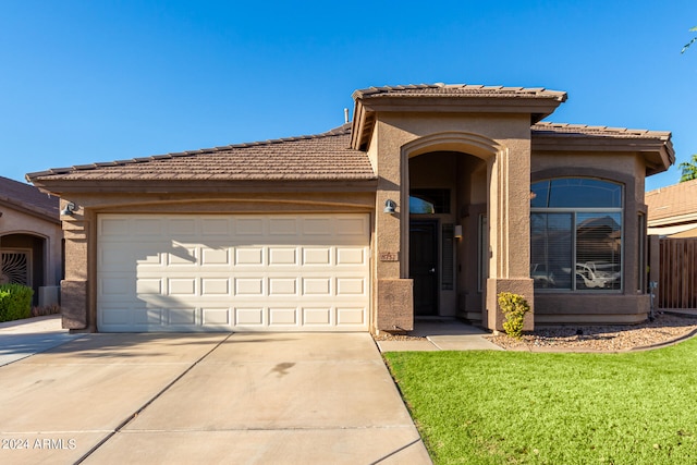 view of front of home with a front lawn and a garage