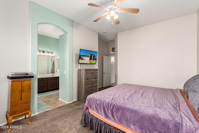 bedroom featuring ceiling fan, light carpet, and ensuite bathroom