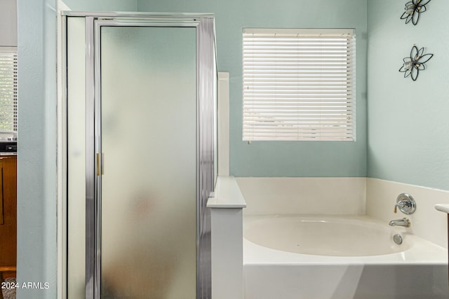 bathroom featuring plus walk in shower and plenty of natural light