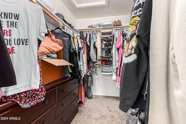 walk in closet featuring light carpet