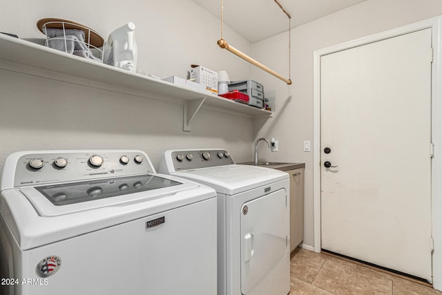 washroom with cabinets, light tile patterned flooring, separate washer and dryer, and sink