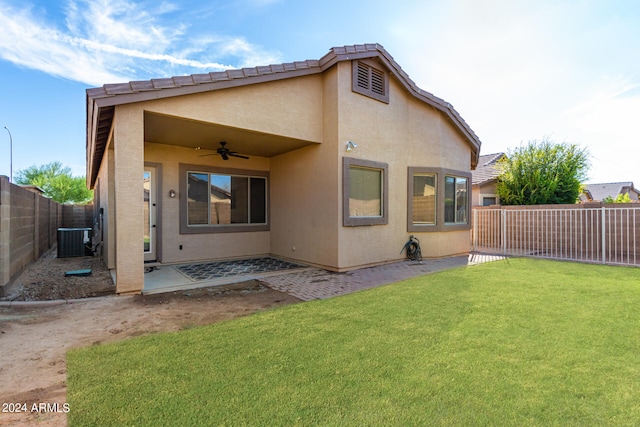 back of property with a lawn, central air condition unit, ceiling fan, and a patio area