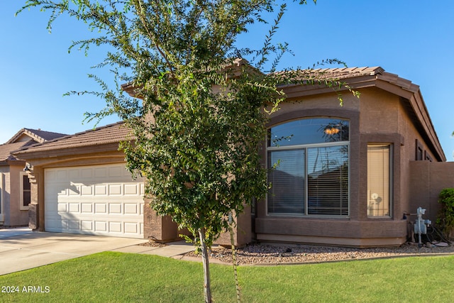 view of front of house with a front yard and a garage