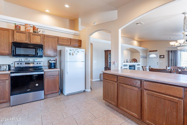 kitchen with light tile patterned flooring, stainless steel electric range oven, and white fridge