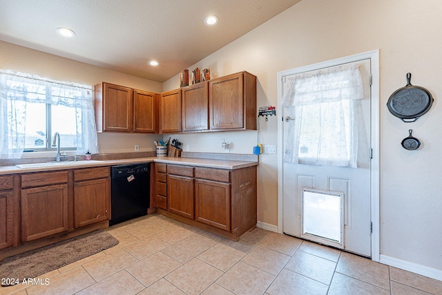 kitchen featuring lofted ceiling, dishwasher, light tile patterned flooring, and sink