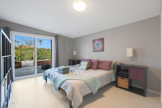 bedroom with access to exterior and light wood-style flooring