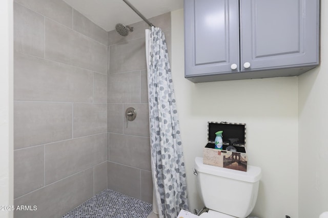 bathroom featuring toilet and tiled shower