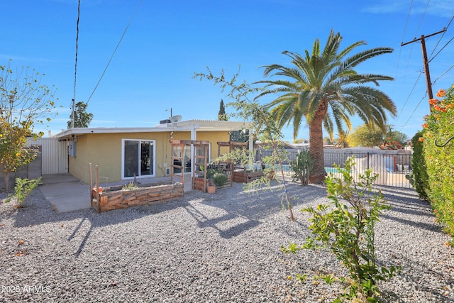 back of property featuring a patio, fence, a garden, a pergola, and stucco siding