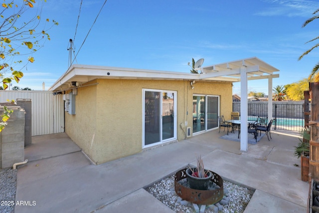 rear view of house with stucco siding, fence, outdoor dining space, and a patio area