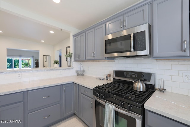 kitchen featuring recessed lighting, stainless steel appliances, tasteful backsplash, and gray cabinets