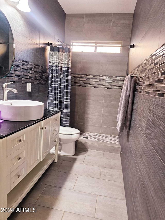 bathroom with vanity, curtained shower, toilet, and tile walls