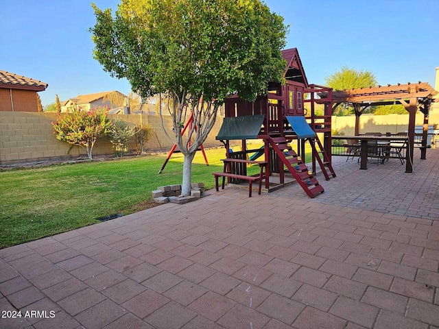 view of playground featuring a pergola, a patio area, and a lawn