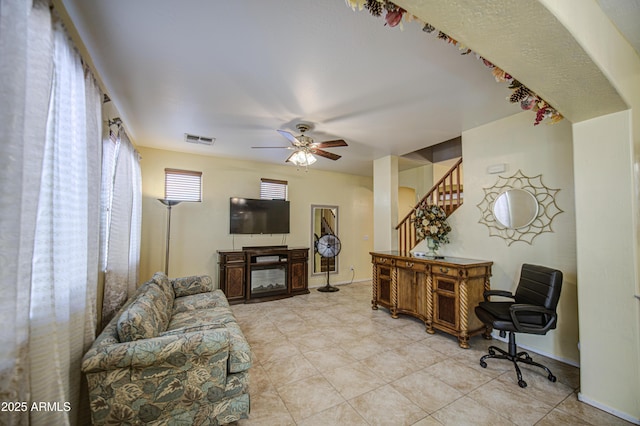 17374 W Adams St, Goodyear, AZ 85338 - living area with light tile patterned floors, visible vents, a ceiling fan, and stairs