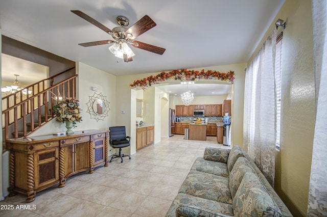 17374 W Adams St, Goodyear, AZ 85338 - living area with stairway, ceiling fan with notable chandelier, arched walkways, and light tile patterned floors