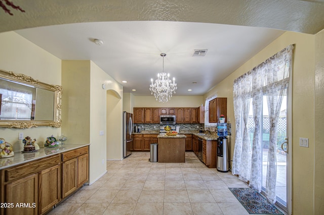 17374 W Adams St, Goodyear, AZ 85338 - kitchen featuring an inviting chandelier, decorative backsplash, visible vents, appliances with stainless steel finishes, and a kitchen island