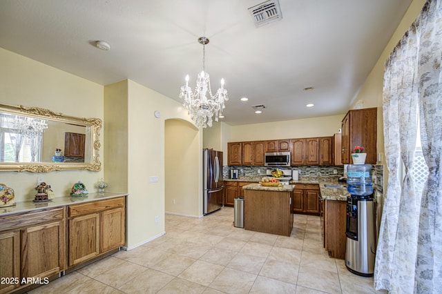 17374 W Adams St, Goodyear, AZ 85338 - kitchen featuring visible vents, a chandelier, decorative backsplash, a center island, and appliances with stainless steel finishes
