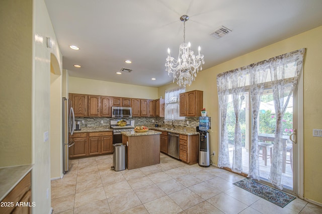 17374 W Adams St, Goodyear, AZ 85338 - kitchen featuring stainless steel appliances, light tile patterned flooring, decorative backsplash, a center island, and a notable chandelier