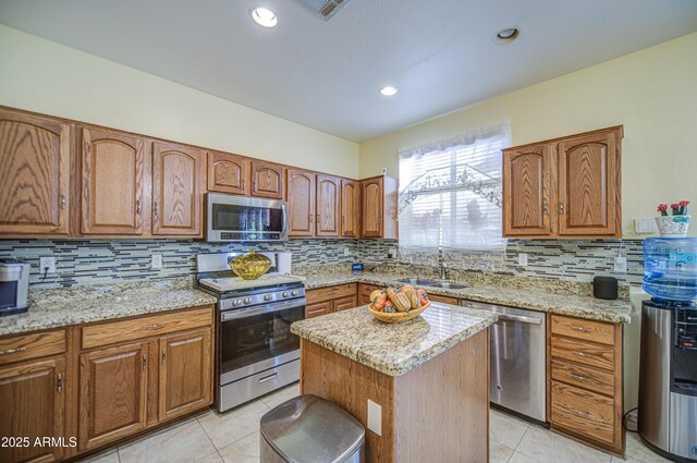 17374 W Adams St, Goodyear, AZ 85338 - kitchen with light tile patterned floors, stainless steel appliances, brown cabinetry, and tasteful backsplash