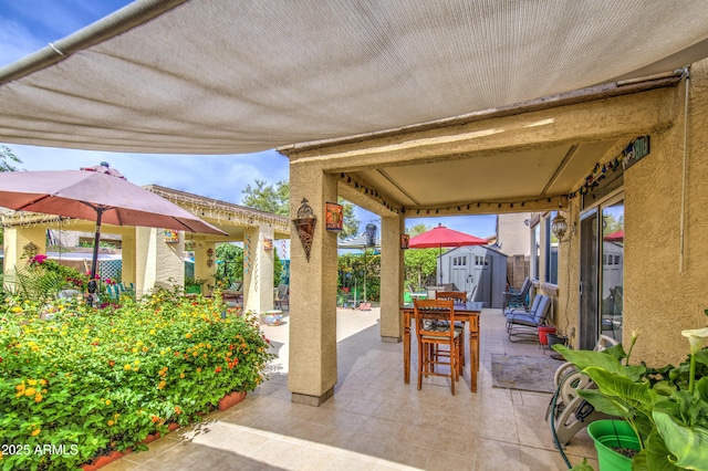 17374 W Adams St, Goodyear, AZ 85338 - view of patio featuring outdoor dining space, an outdoor structure, and a storage unit