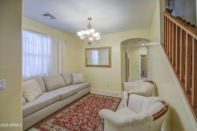 17374 W Adams St, Goodyear, AZ 85338 - living room featuring baseboards, an inviting chandelier, visible vents, arched walkways, and stairway