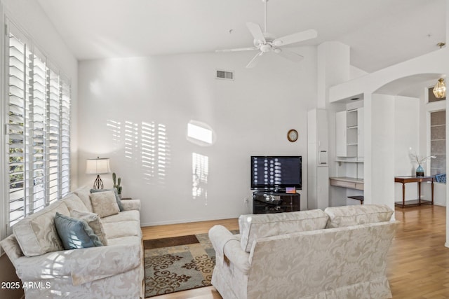 living room featuring lofted ceiling, light wood-type flooring, and a wealth of natural light