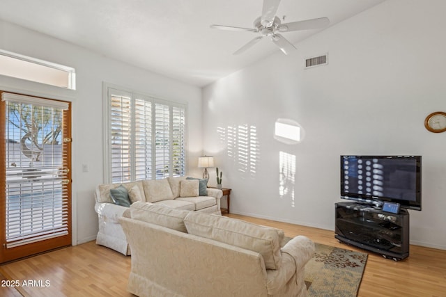 living room featuring ceiling fan, light hardwood / wood-style flooring, and vaulted ceiling