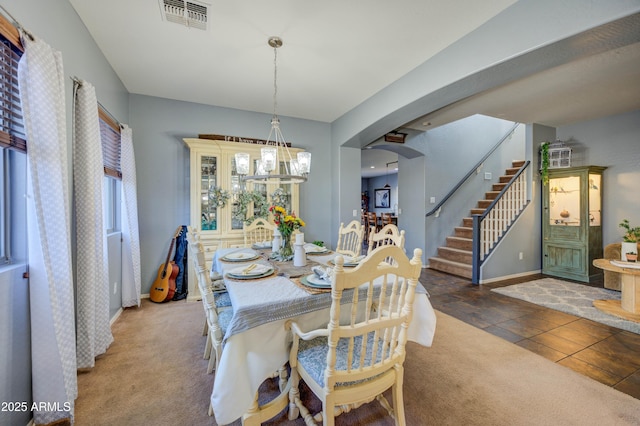 carpeted dining space featuring a chandelier