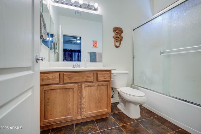 full bathroom featuring toilet, vanity, and bath / shower combo with glass door