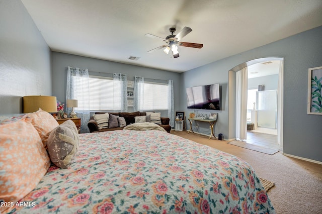 carpeted bedroom featuring ceiling fan and ensuite bath