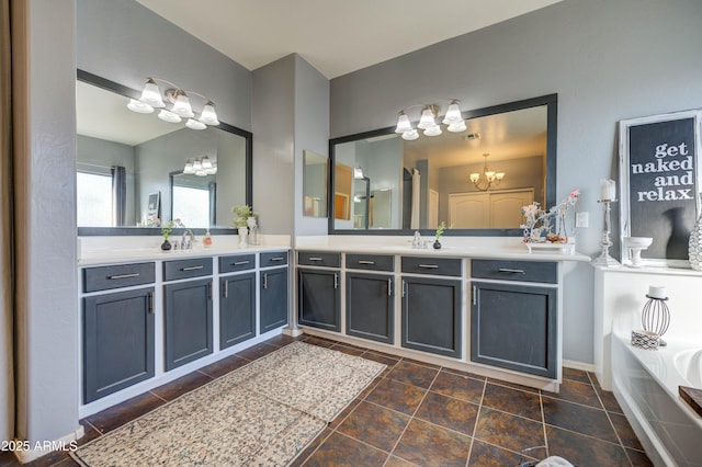 bathroom featuring vanity, a chandelier, and a bathtub