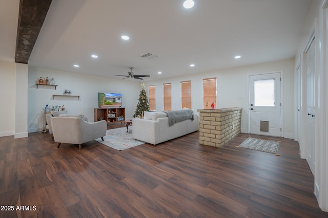 living room with ceiling fan and dark wood-type flooring