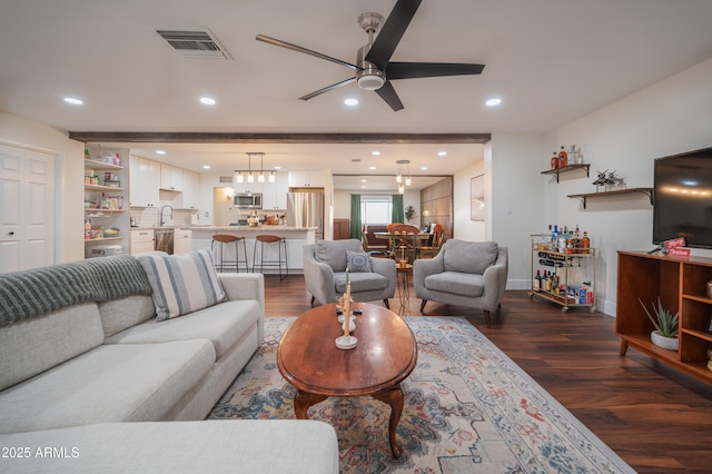 living room with beam ceiling, dark hardwood / wood-style floors, ceiling fan, and sink