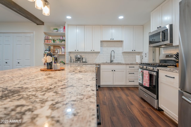 kitchen with sink, decorative backsplash, appliances with stainless steel finishes, beam ceiling, and white cabinetry