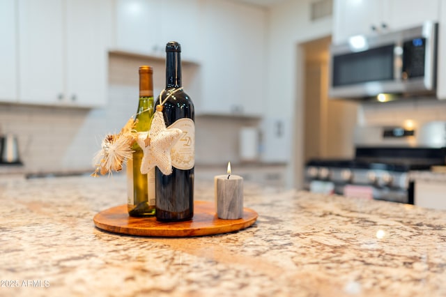 interior details featuring stainless steel range and white cabinets