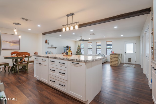 kitchen featuring white cabinets, hanging light fixtures, ceiling fan, beam ceiling, and a kitchen island