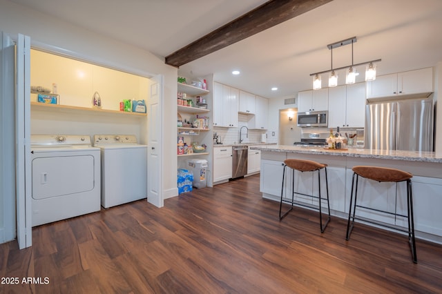 laundry room with sink, independent washer and dryer, and dark wood-type flooring