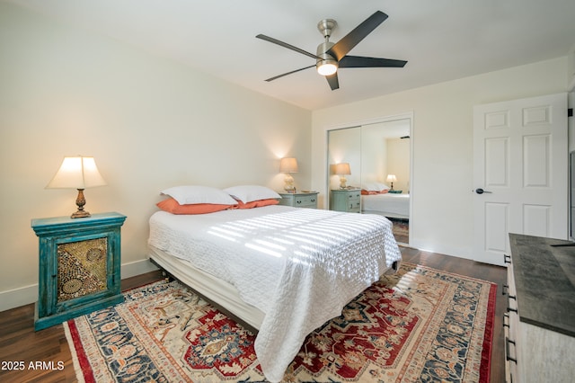 bedroom with ceiling fan, dark wood-type flooring, and a closet