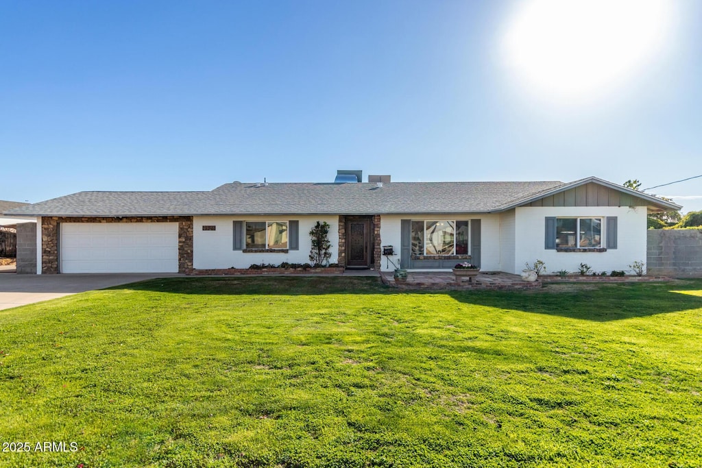 single story home featuring a garage and a front yard