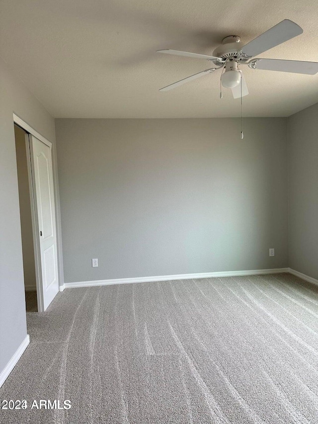 spare room with carpet flooring and ceiling fan