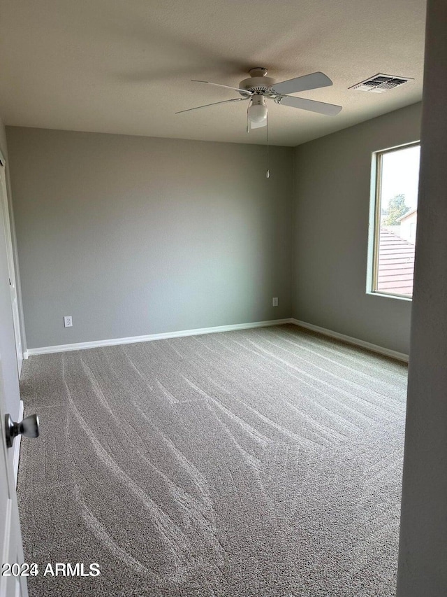 empty room featuring carpet flooring and ceiling fan