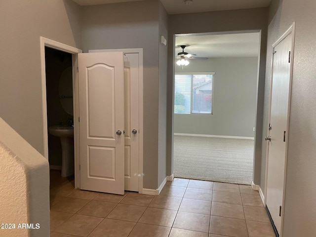 hall with light tile patterned floors and sink