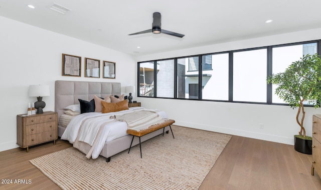 bedroom featuring light wood-type flooring, multiple windows, and ceiling fan