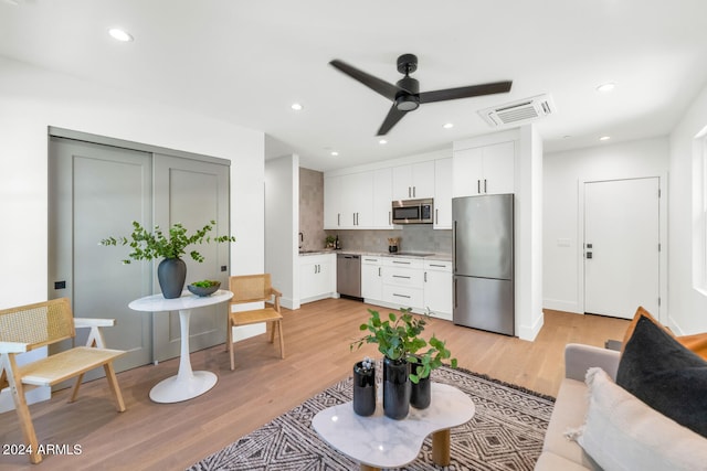 living room featuring ceiling fan, sink, and light hardwood / wood-style floors