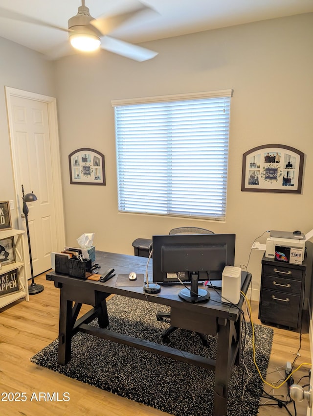 home office featuring wood-type flooring, a healthy amount of sunlight, and ceiling fan