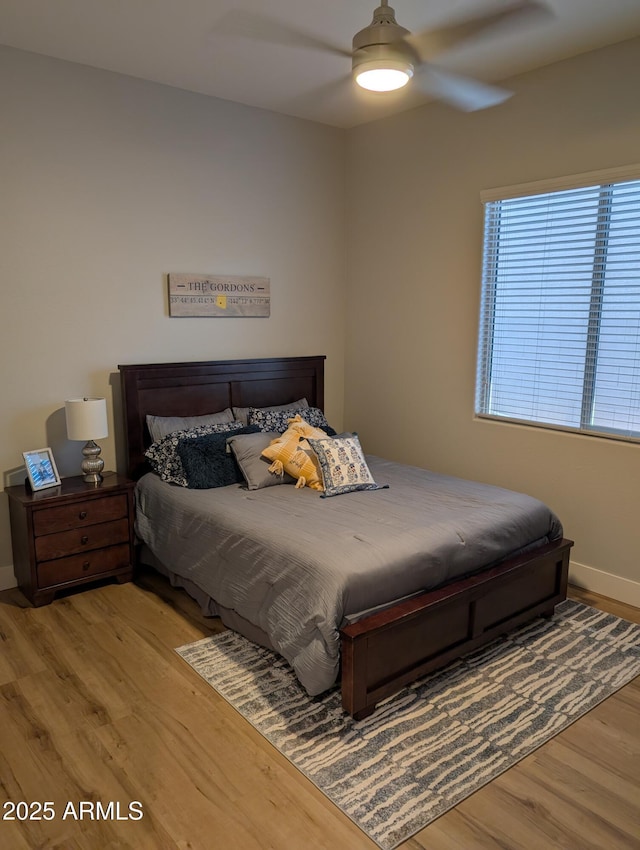 bedroom with ceiling fan and light hardwood / wood-style floors