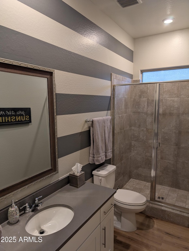 bathroom with vanity, wood-type flooring, toilet, and walk in shower