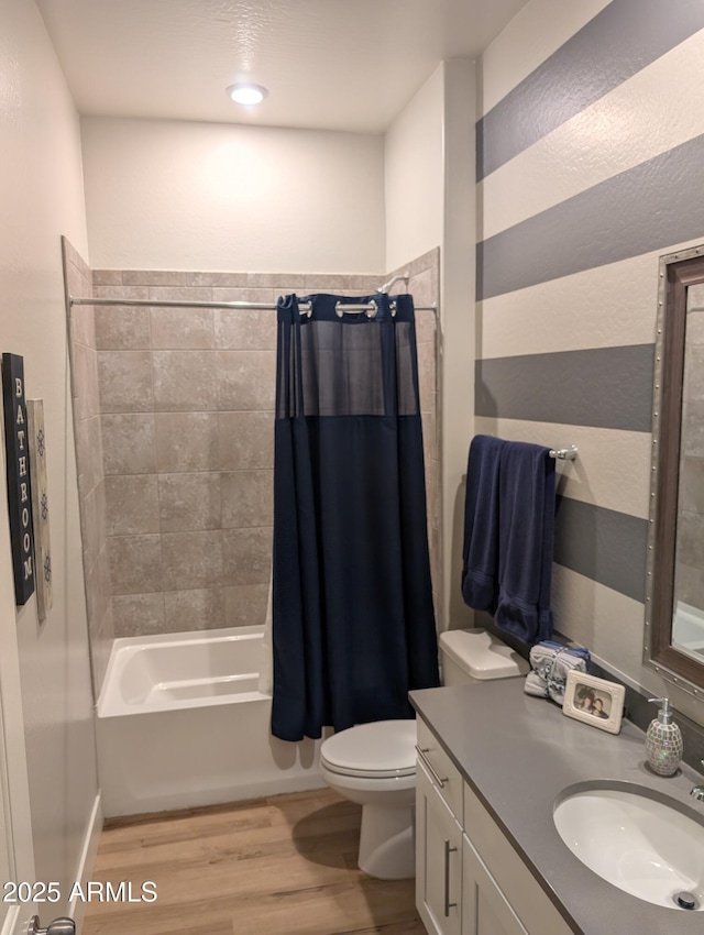 full bathroom featuring shower / tub combo with curtain, hardwood / wood-style floors, vanity, and toilet