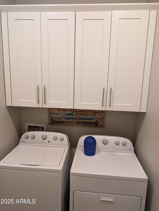 clothes washing area featuring cabinets and washing machine and dryer